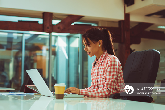 Young woman working on laptop in the office