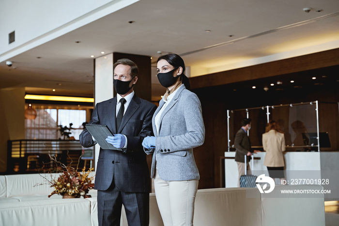 Hotel employee working in team while guests arriving