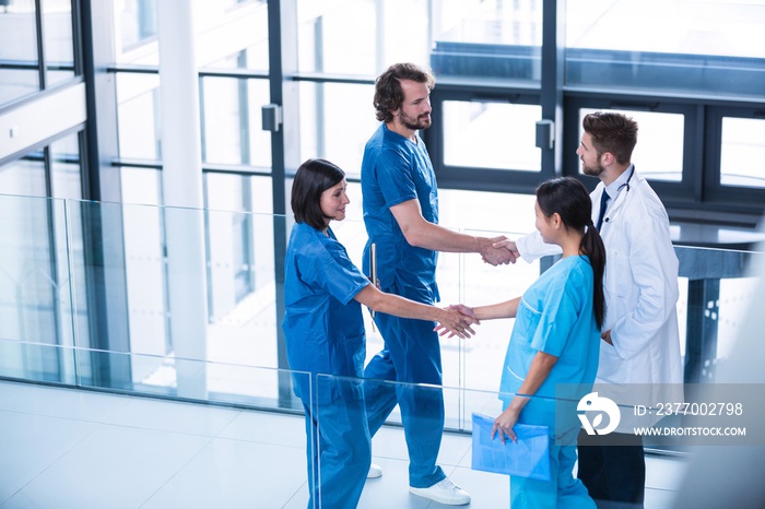 Surgeons, doctor and nurse shaking hands with each other