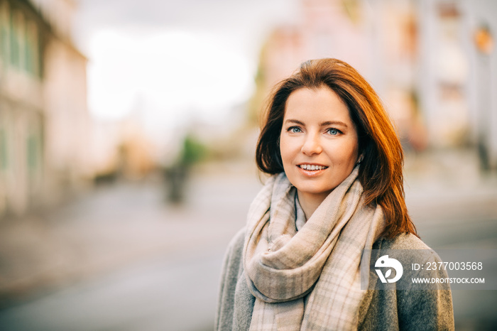 Outdoor portrait of beautiful woman wearing grey coat