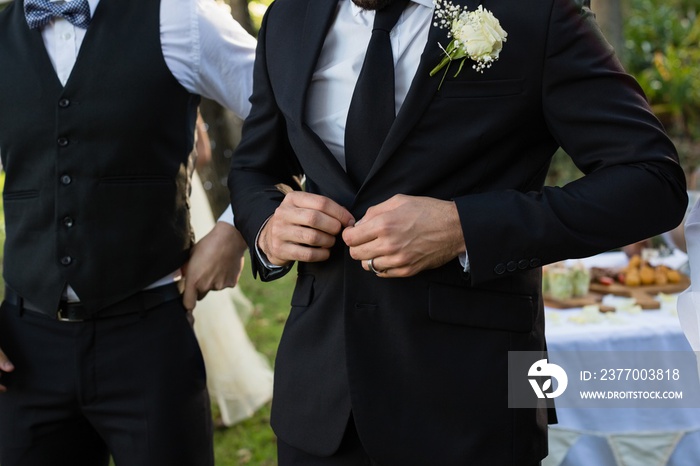 Bridegroom buttoning a wedding suit