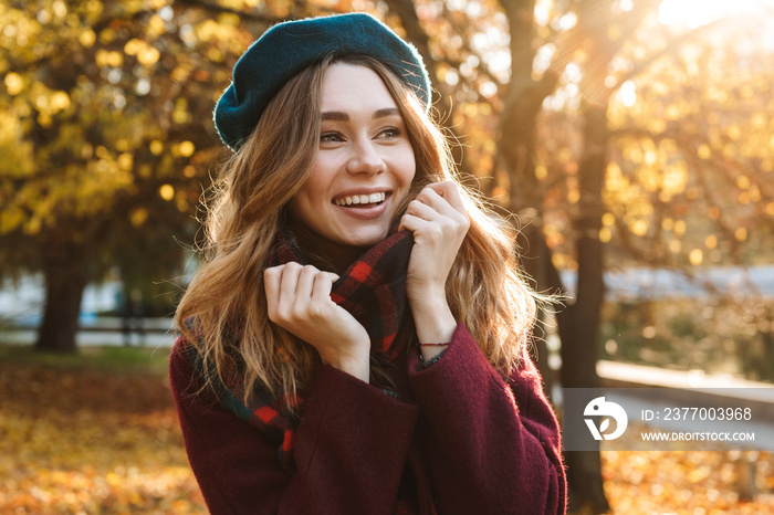 Beautiful young pretty woman walking outdoors in autumn spring park.