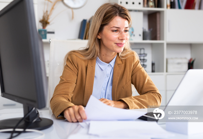 Successful adult business woman using laptop at workplace