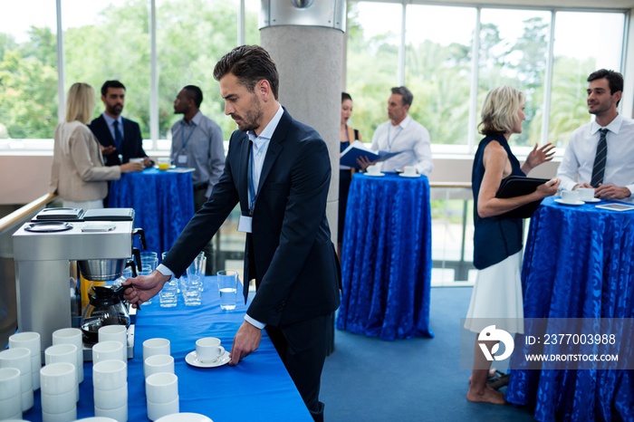 Business executive taking coffee from coffee maker