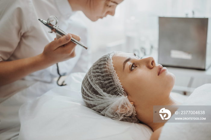 Caucasian woman receiving face oxygen peeling at cosmetology center. Facial skin treatment. Beauty skin. Beauty face. Cosmetology beauty procedure. Skin care.