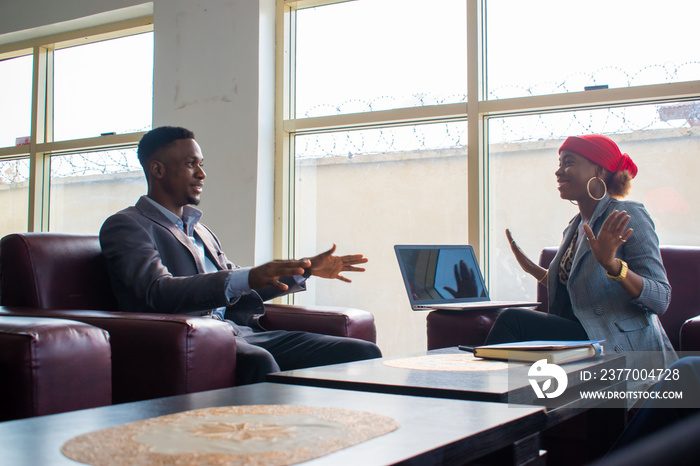 Business meeting. Two business people sitting in front of each other in the office while discussing something.