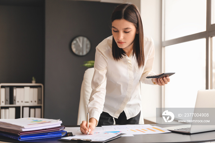 Young female accountant working in office