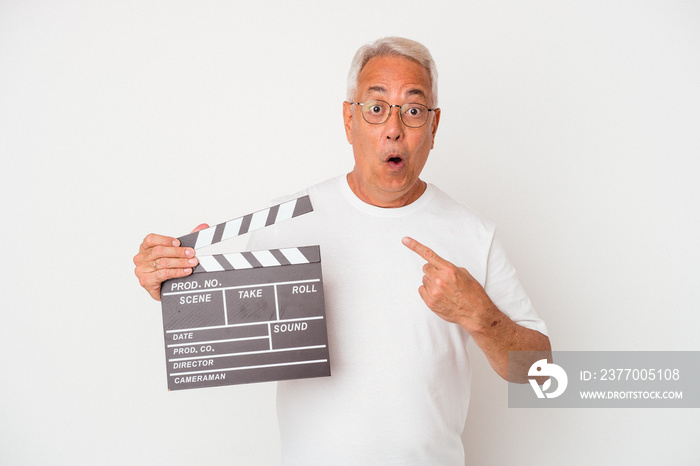 Senior american man holding a clapperboard isolated on white  background pointing to the side