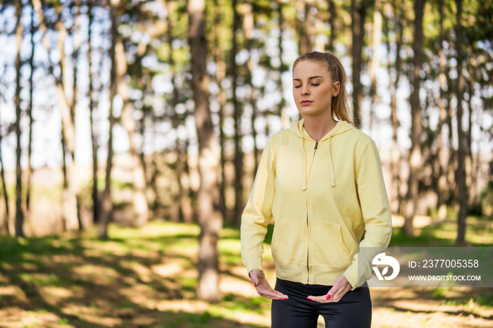 Beautiful woman enjoys exercising Tai Chi in the nature.