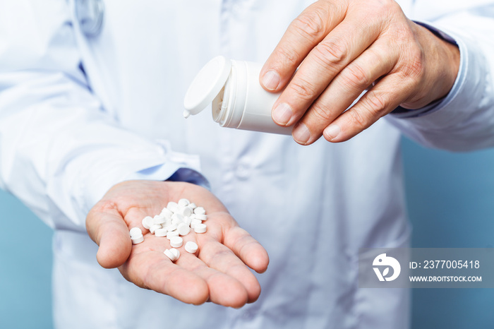 doctor holding bottle of pills on white background. The concept of medicine, pharmacology, healthcare