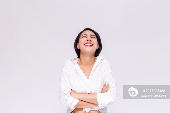 Young beautiful and confident Asian girl with short hair arms crossed with joy and happiness in white isolated background.