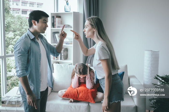 mother and father fighting together and daughter sitting with sad motion at home, young family concept