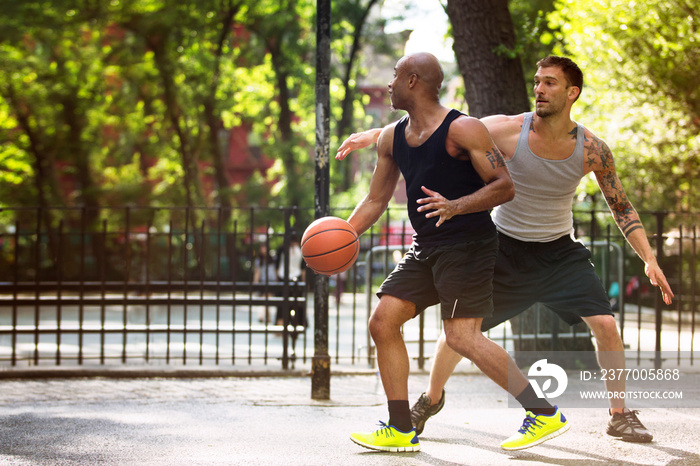 Men playing basketball on court