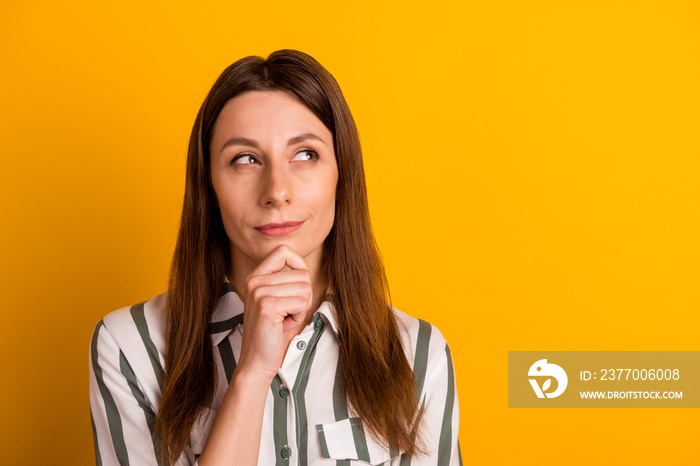 Photo of young pretty woman hand touch chin look empty space thoughtful isolated over yellow color background