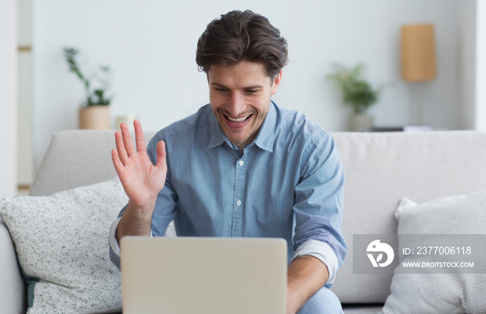 Happy Man Waving Hand Making Video Call Via Laptop Indoor