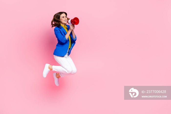 Full length photo of active excited person hold loudspeaker jumping empty space isolated on pink color background