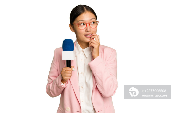 Young TV Asian presenter isolated on green chroma background relaxed thinking about something looking at a copy space.