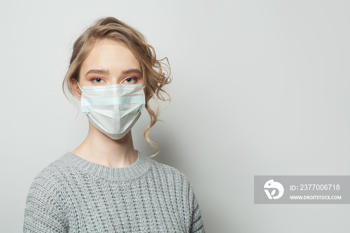 Pretty woman in a face mask on white background. Woman in medical mask. Flu epidemic and virus protection concept