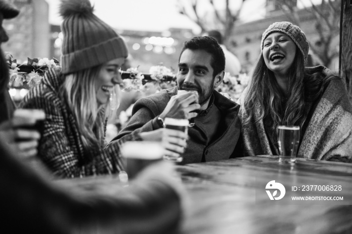 Young people having fun drinking beer at pub restaurant - Soft focus on right girl face - Black and white editing