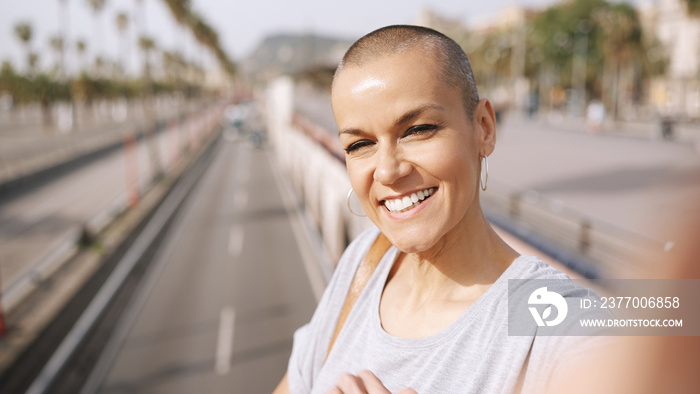 Adult white woman with short hairstyle standing on bridge over highway