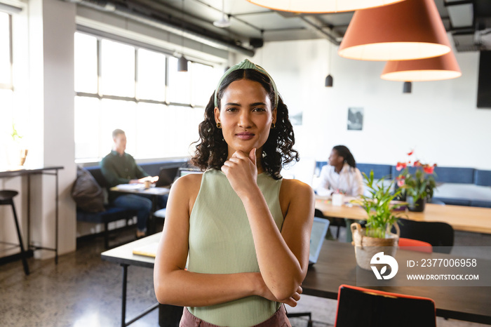 Portrait of confident young biracial businesswoman in creative office