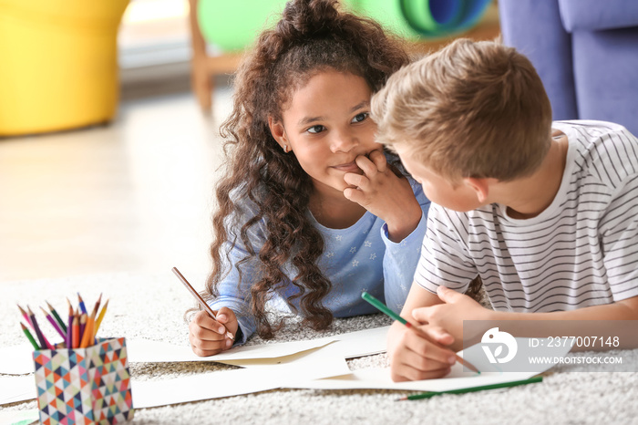 Happy adopted children drawing pictures in their new home