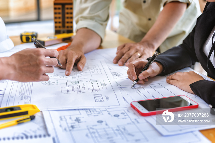 Image of team engineer checks construction blueprints on new project with engineering tools at desk in office.