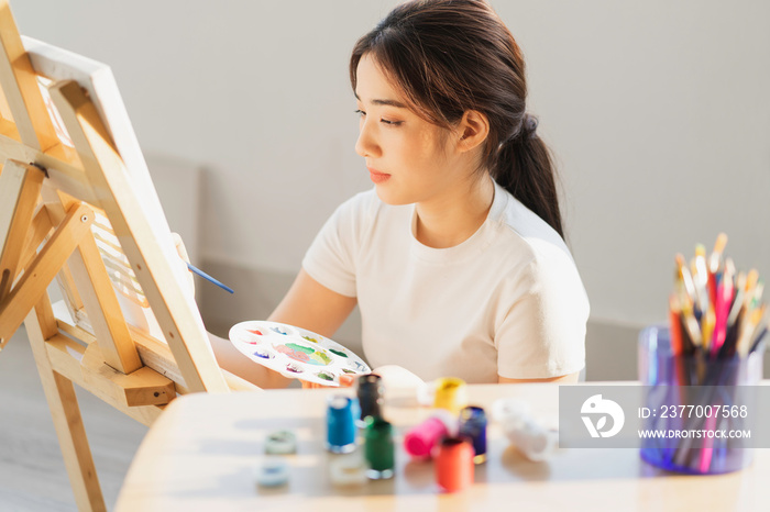 Young girl sitting on the floor learning to draw by herself