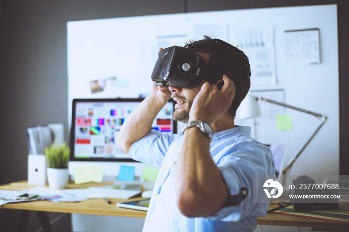 Young male software programmer testing a new app with 3d virtual reality glasses in office.