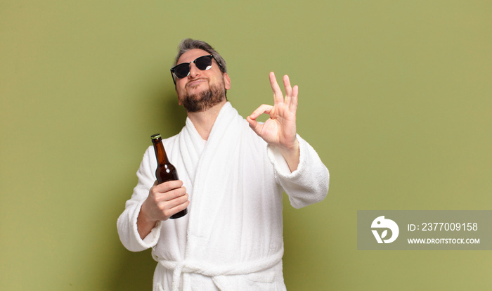 middle age man wearing bath robe and drinking a beer