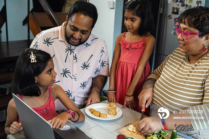 Kids helping their parent cook a healthy meal for the family dinner at home