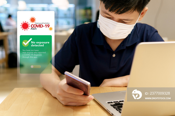 Covid 19 Alert application on devices concept. A smart looking teenager boy checking on digital contact-tracing apps on his smartphone and it’s show  No exposure detected . Pandemic, Healthcare Tech.