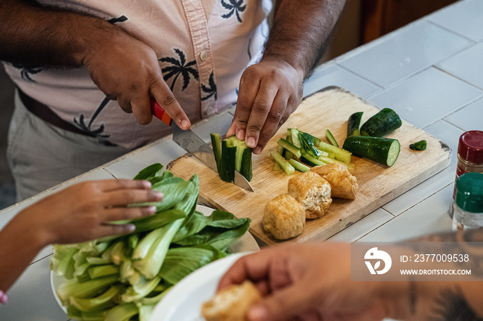 Kids helping their parent cook a healthy meal for the family dinner at home