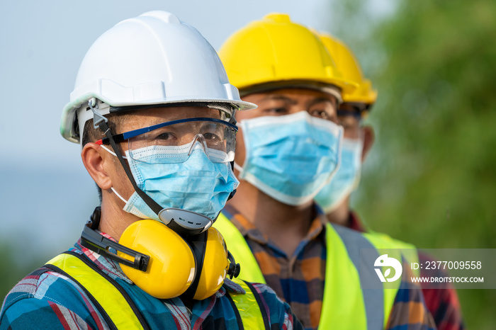 Workers wear protective face masks for safety working at solar power station,Coronavirus has turned into a global emergency.