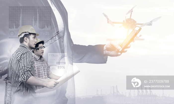 Smart construction , augmented reality in industry 4.0 concept. Double exposure of Business hand suit using mobile phone and two engineers using ar glasses with graphic popup,drone,crane,harbor.