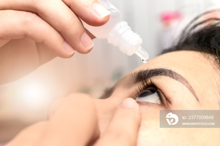 Closeup woman using eye drop. Woman applying eye drops healthcare concept.