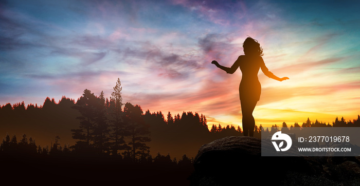 free and happy woman raises her arms at sunset