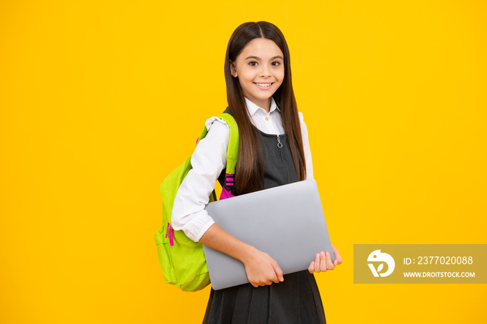 Back to school. Teenager schoolgirl hold notebook laptop. School children on isolated yellow studio background. Happy girl face, positive and smiling emotions.