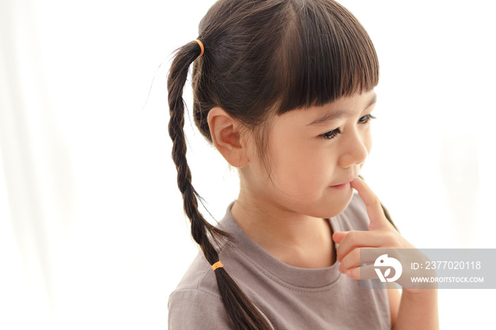 Cute little Asian girl with pigtails She was in a good mood, smiling happily. positive person. white background