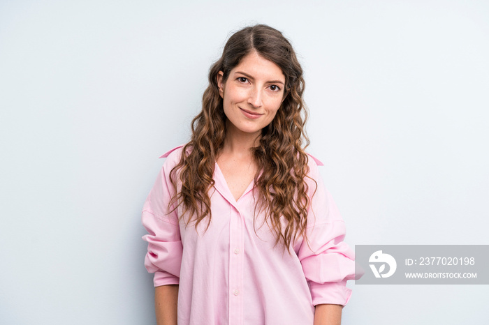 young adult pretty woman smiling cheerfully and casually with a positive, happy, confident and relaxed expression