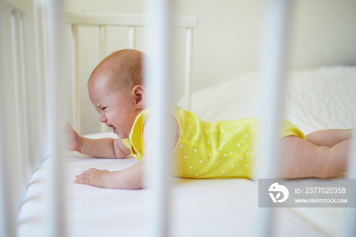 Baby girl in co-sleeper crib