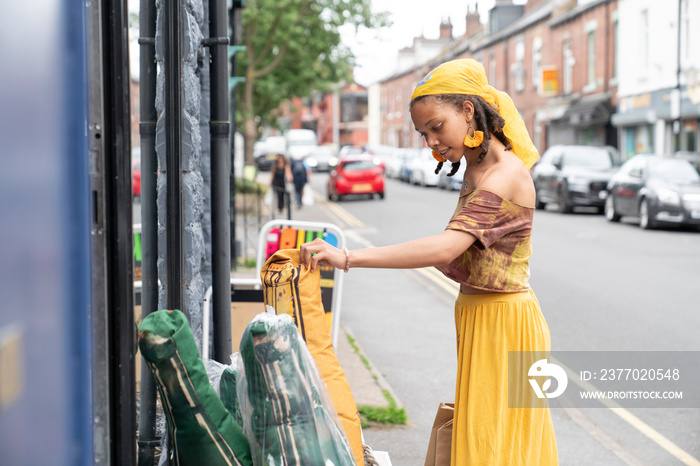 Young woman looking at outdoor display in city