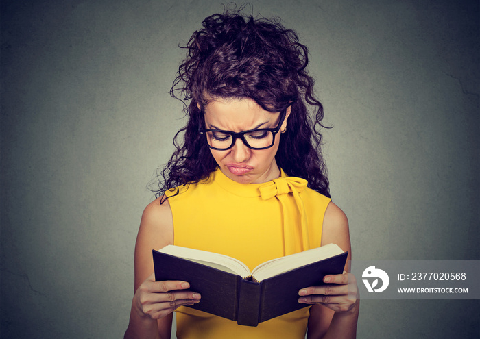 Thoughtful displeased woman reading a book