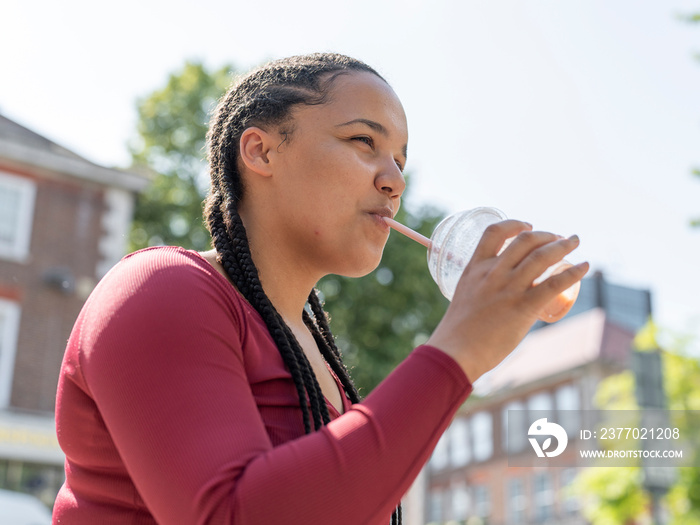 Side view of woman drinking smoothie