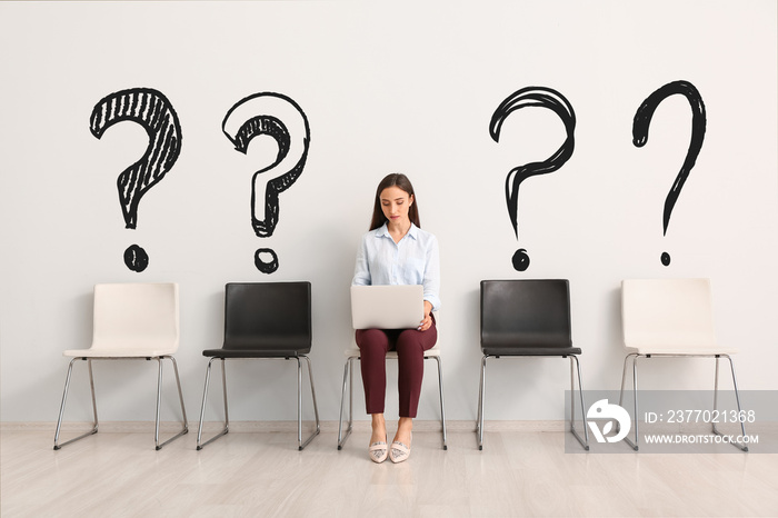 Young woman with laptop waiting for job interview indoors