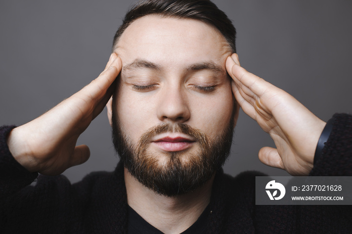 Thoughtful man rubbing temples