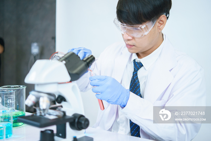 Asian scientists are seriously studying the chemical composition in the laboratory. Specializing in Young Biotechnology Use advanced microscope equipment.