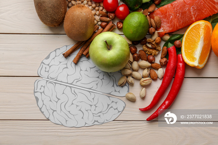 Human brains with different healthy products on white wooden background