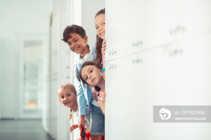 Boy and girls smiling while standing near lockers at school break