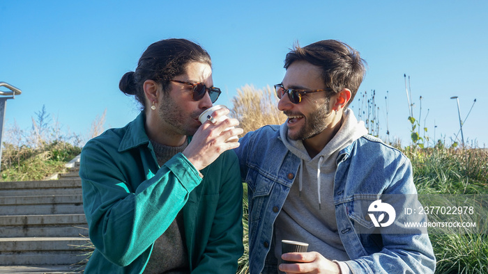 Smiling gay couple relaxing on bench